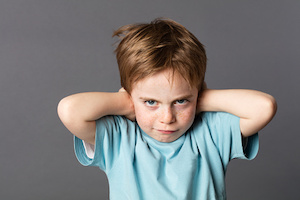 stubborn young kid teasing, covering closed ears, ignoring parents